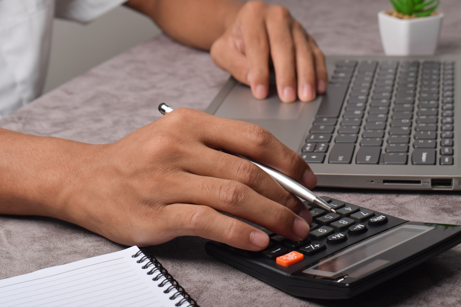 Businessman using calculator for payroll bookkeeping